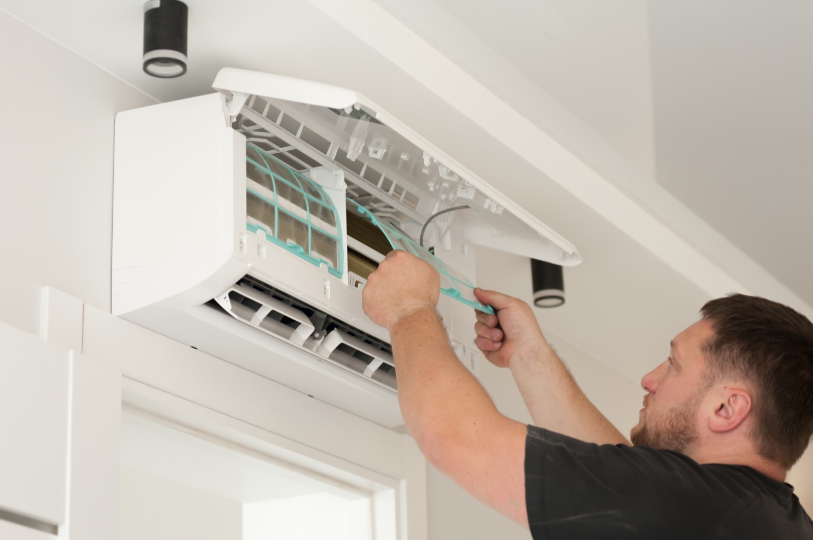 Engineer working on a wall mounted air conditioning unit in Reading, Berkshire